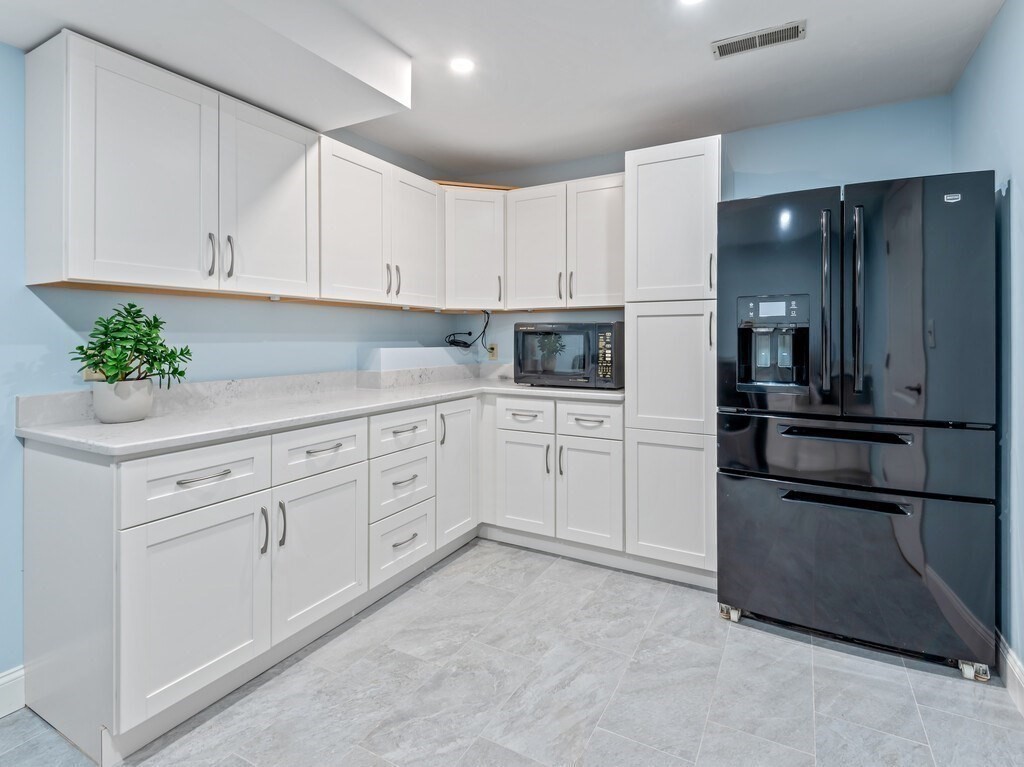 1 Corbin Road Dudley, MA 01571 - Photo 21 of 42 a kitchen with white cabinets and stainless steel appliances