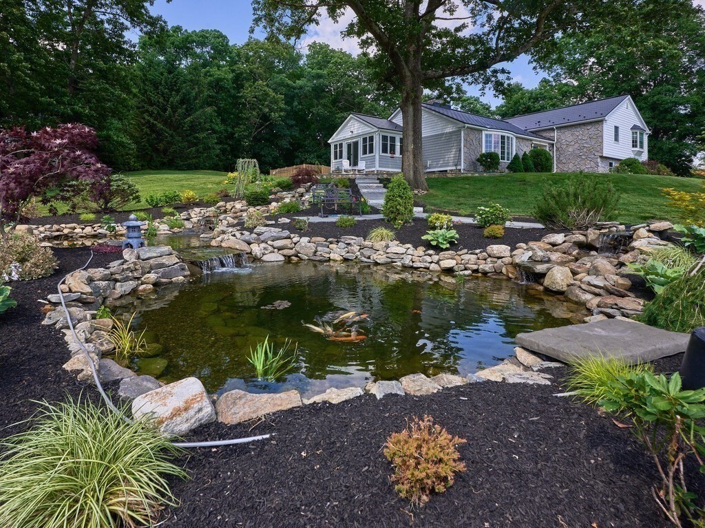 1 Corbin Road Dudley, MA 01571 - Photo 23 of 42 a front view of a house with a yard and a lot of flower garden