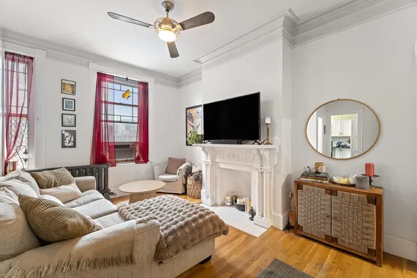 a bedroom with a bed a mirror on dresser and a flat screen tv