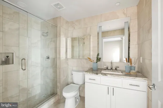a bathroom with a granite countertop toilet sink and mirror
