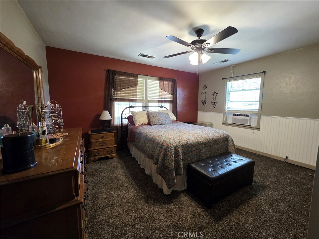 23773 River Road Corning, CA 96021 - Photo 24 of 64 a bedroom with a bed and a chandelier