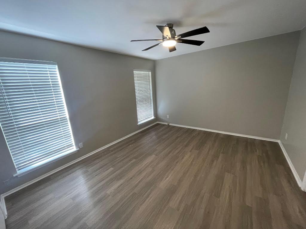 8105 Ceberry Drive, Unit B Austin, TX 78759 - Photo 5 of 12 an empty room with wooden floor fan and windows
