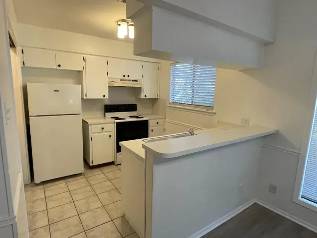 a kitchen with a sink a stove a refrigerator and a cabinets