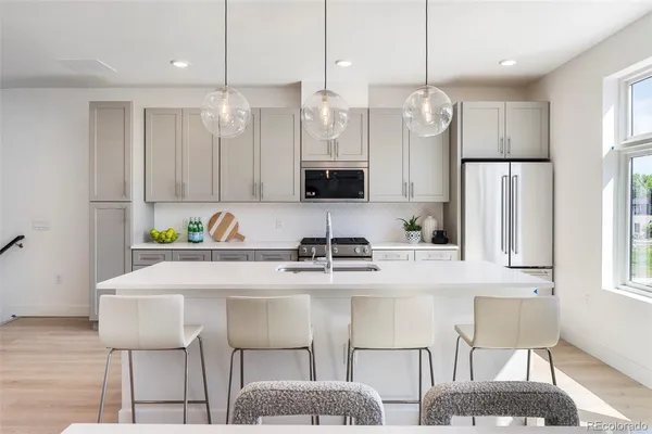 a kitchen with stainless steel appliances granite countertop a sink a microwave a refrigerator and a stove