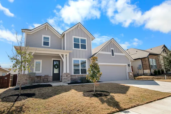 a view of a white house with a yard and large tree
