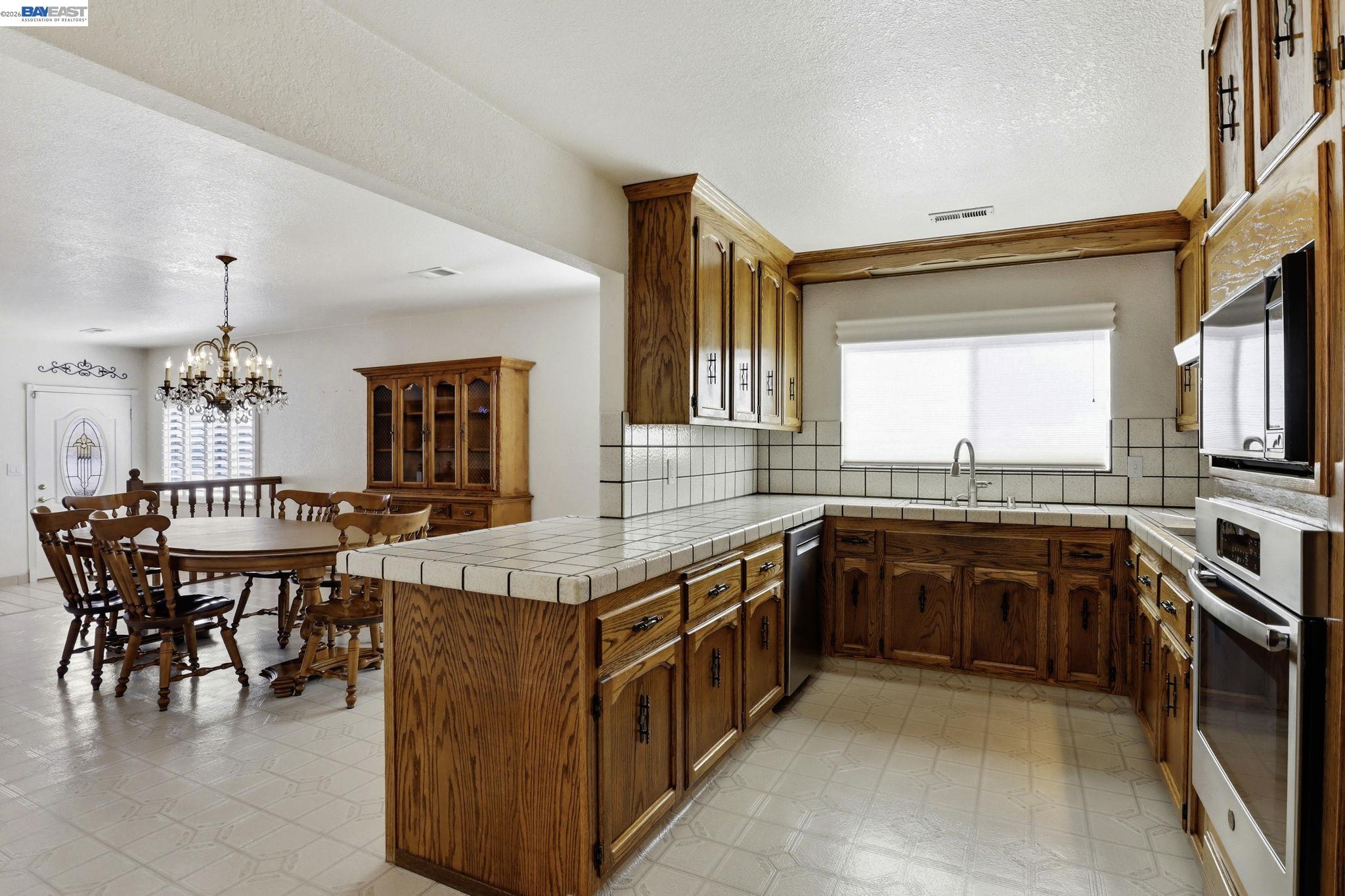 559 Cherry Way Hayward, CA 94541 - Photo 22 of 50 a kitchen with stainless steel appliances granite countertop a stove and a wooden cabinets
