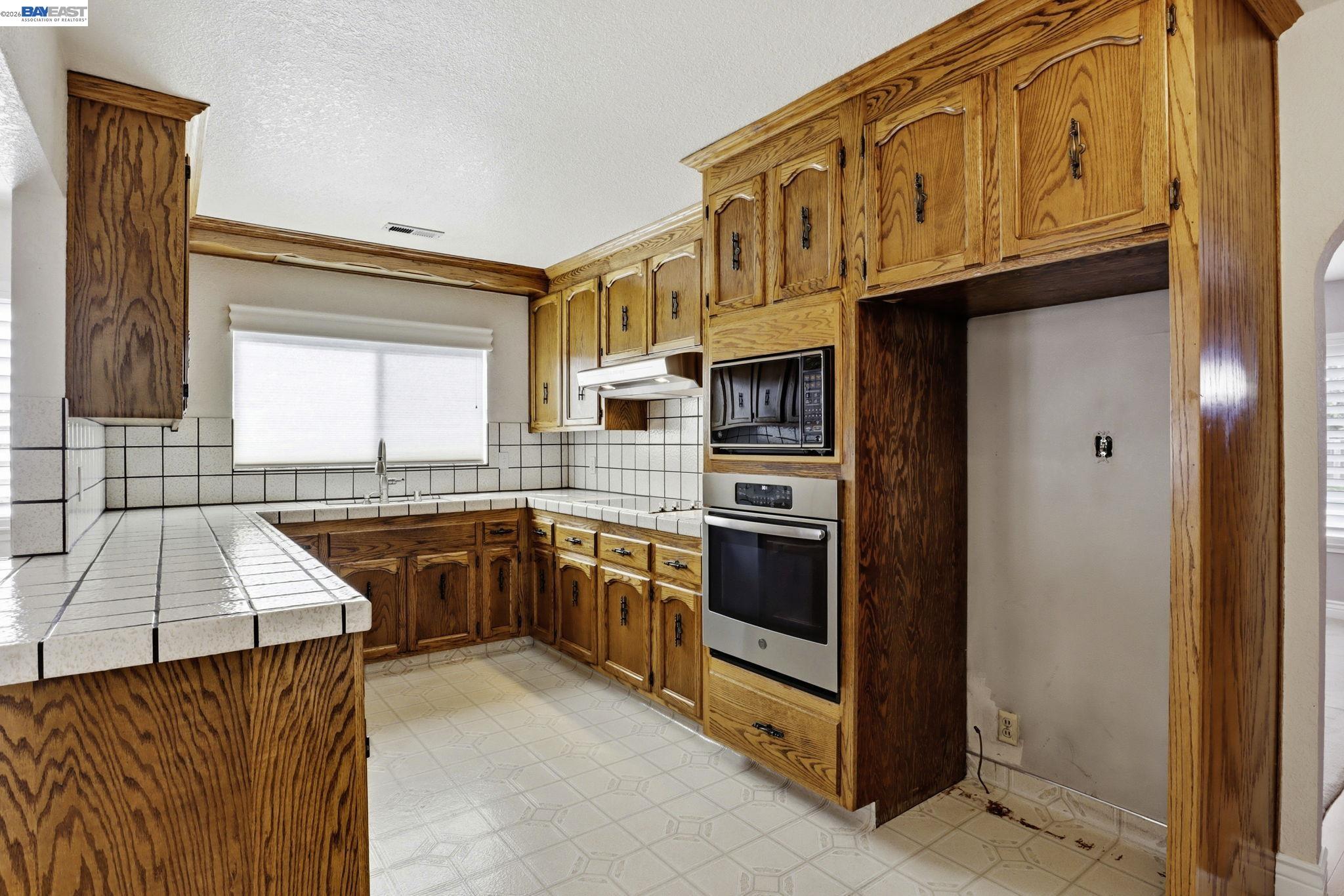 559 Cherry Way Hayward, CA 94541 - Photo 23 of 50 a kitchen with stainless steel appliances granite countertop a refrigerator and a stove top oven