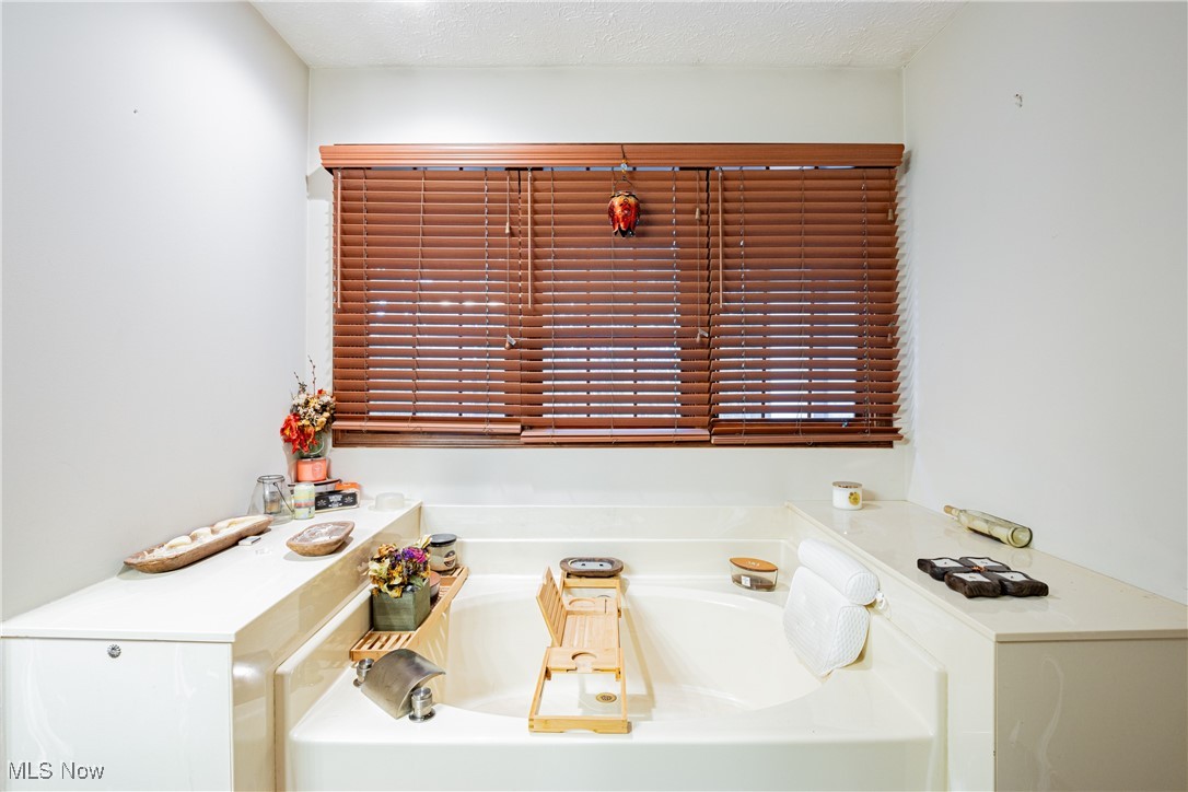 6743 Cedar Ridge Trail Clinton, OH 44216 - Photo 31 of 42 Bathroom with a textured ceiling and a tub to relax in