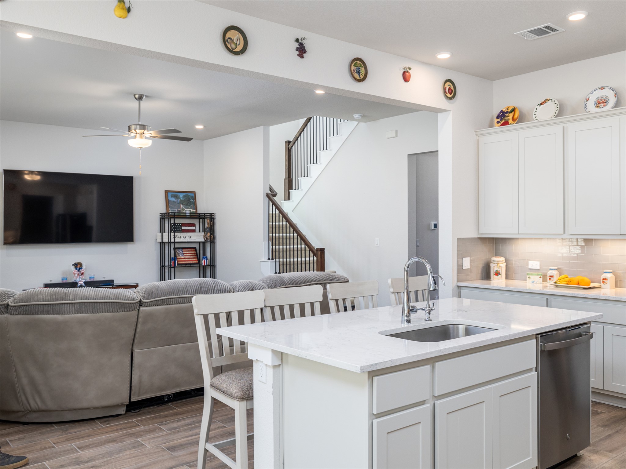 245 Brooks Ranchi Drive Kyle, TX 78640 - Photo 16 of 16 Kitchen featuring a kitchen breakfast bar, white cabinets, open floor plan, light stone countertops, and recessed lighting