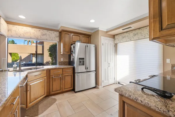 a kitchen with stainless steel appliances granite countertop a refrigerator and a sink