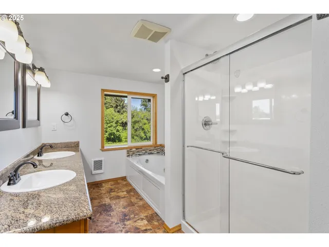 a bathroom with a granite countertop sink mirror bathtub and shower