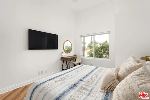 a bedroom with a bed and a flat screen tv