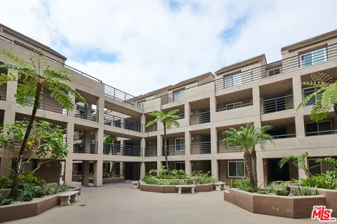 a front view of a building with a garden and plants
