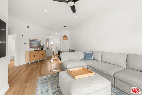 a living room with furniture and a wooden floor