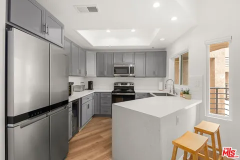 a kitchen with a sink a stove a refrigerator a center island and a window