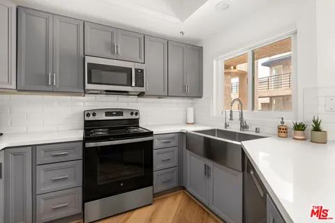 a kitchen with appliances a sink and a stove