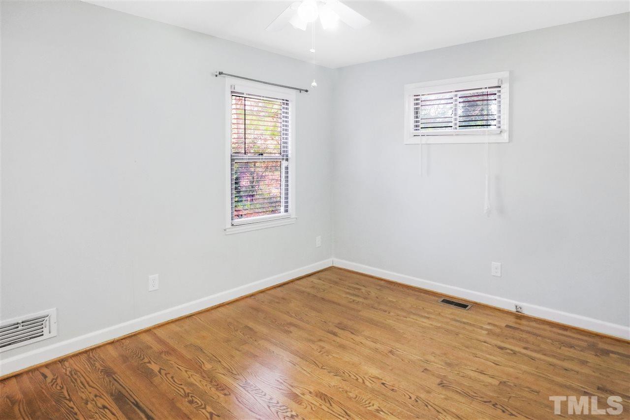 901 Merrie Road Raleigh, NC 27606 - Photo 11 of 18 an empty room with wooden floor and windows