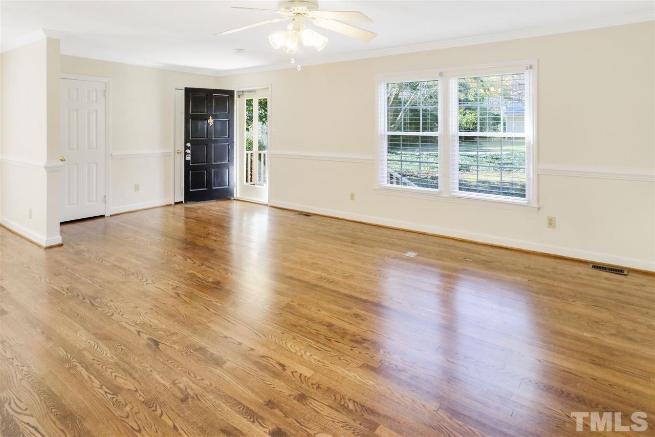 901 Merrie Road Raleigh, NC 27606 - Photo 5 of 18 an empty room with wooden floor and windows