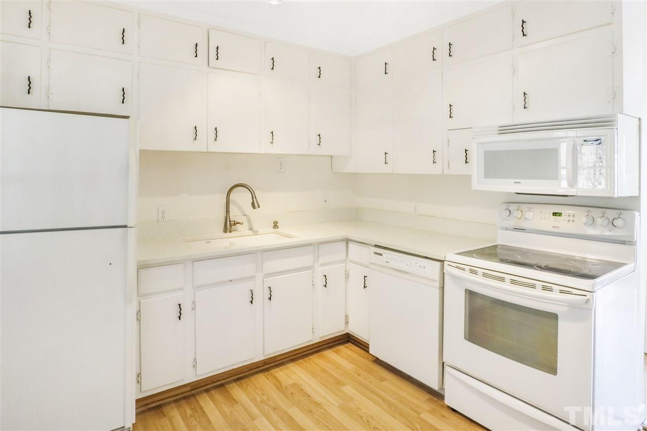 901 Merrie Road Raleigh, NC 27606 - Photo 6 of 18 a kitchen with granite countertop white cabinets and white appliances