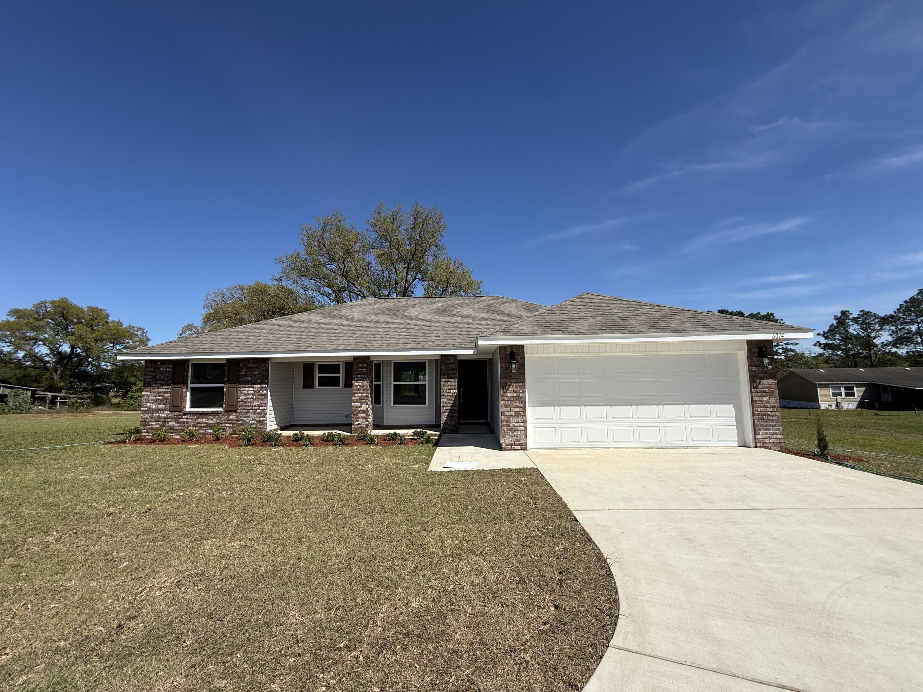 a front view of a house with a yard and seating space