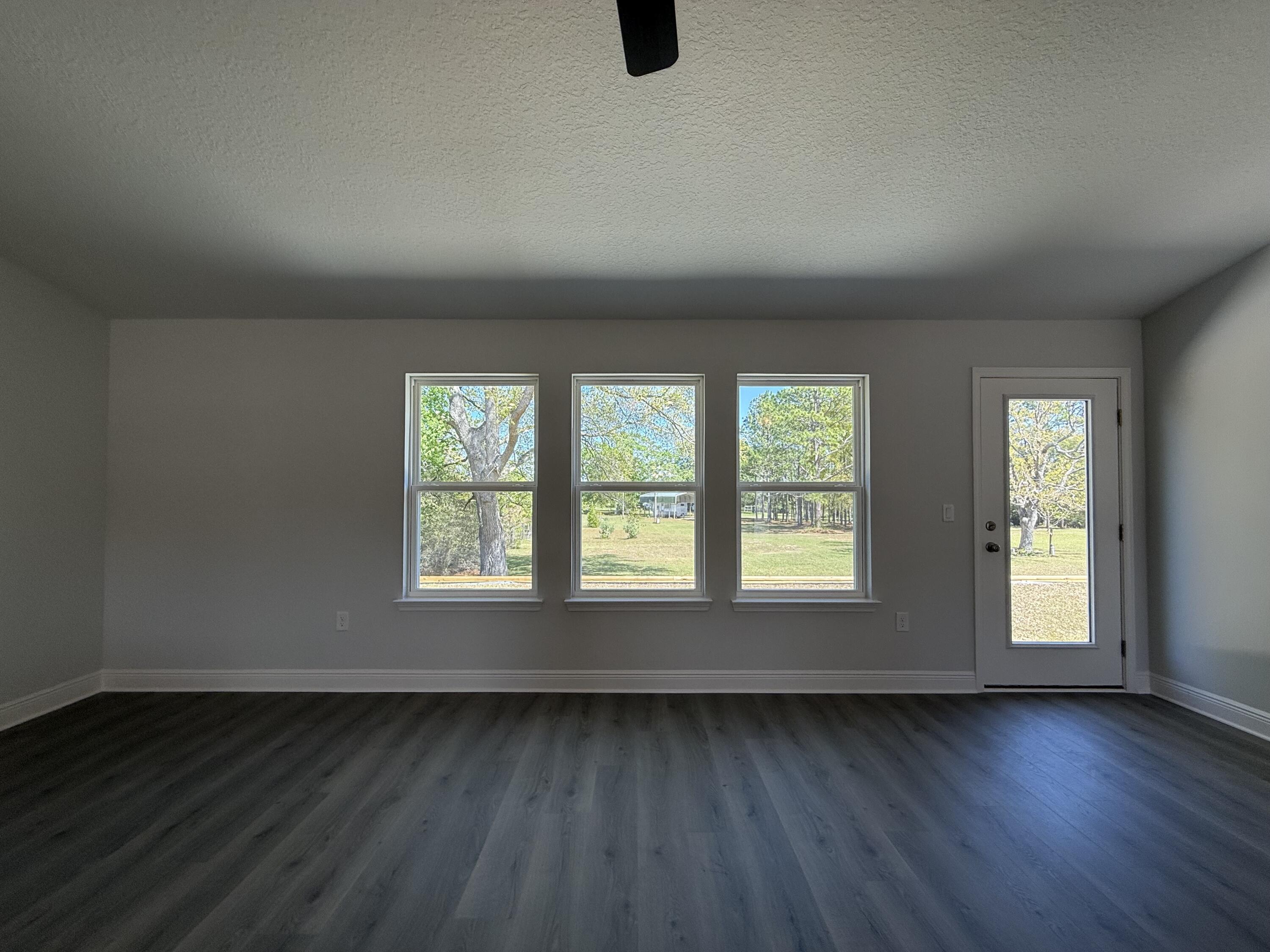 6014 Crocket Cove Crestview, FL 32539 - Photo 12 of 29 an empty room with wooden floor and windows