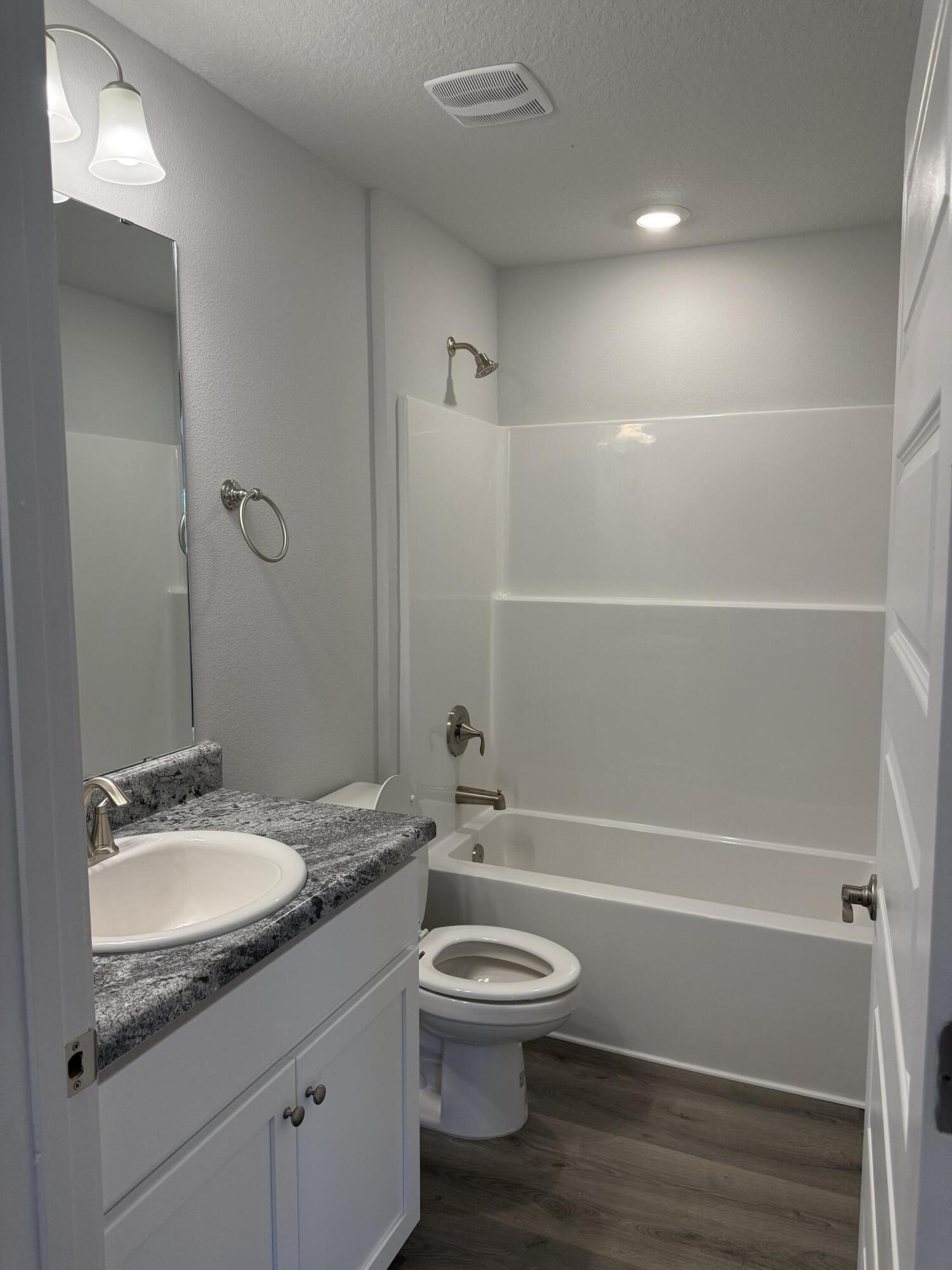 6014 Crocket Cove Crestview, FL 32539 - Photo 22 of 29 a bathroom with a granite countertop toilet a sink and a bathtub