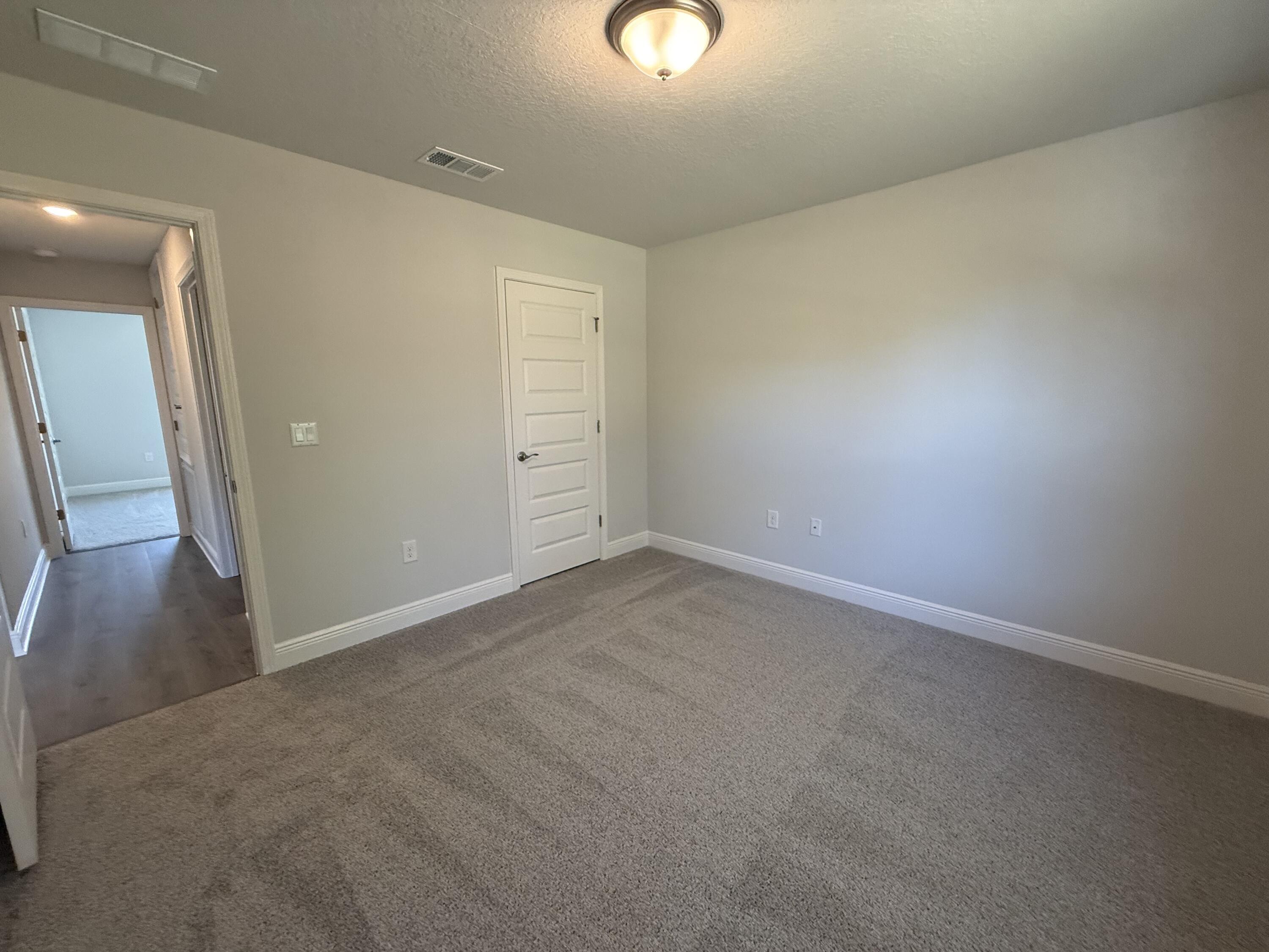 6014 Crocket Cove Crestview, FL 32539 - Photo 25 of 29 an empty room with wooden floor and windows