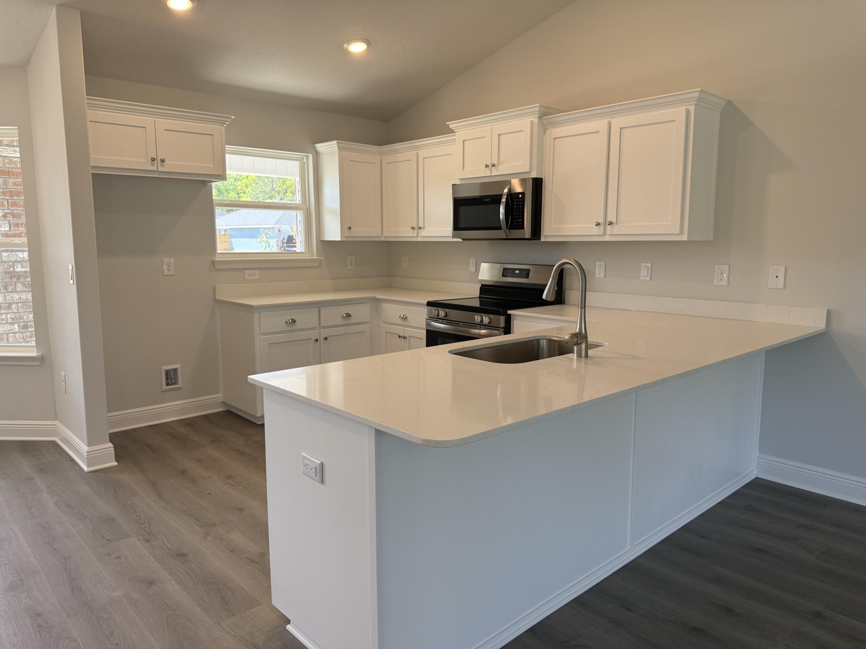 6014 Crocket Cove Crestview, FL 32539 - Photo 8 of 29 a kitchen with stainless steel appliances a sink a stove a microwave a sink a refrigerator and cabinets