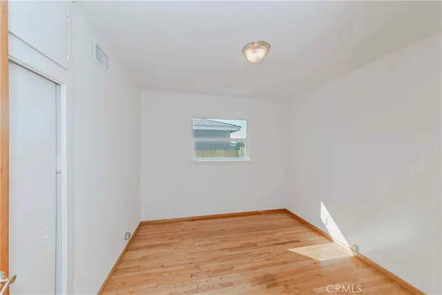 a view of a room with wooden floor and white walls