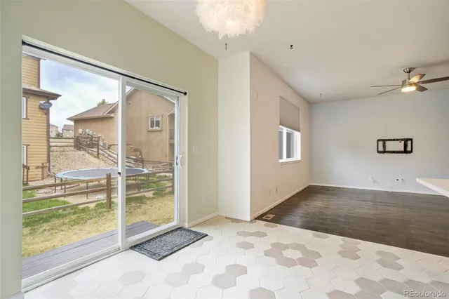 a view of a big room with wooden floor and windows