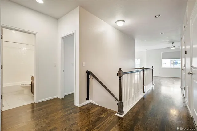 a view of a hallway with wooden floor and staircase