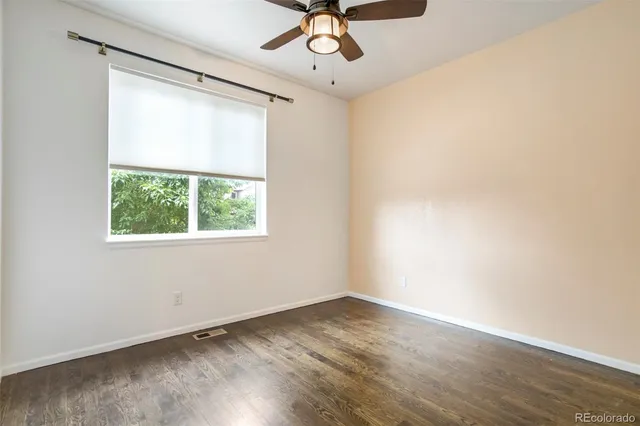 an empty room with a window and a ceiling fan