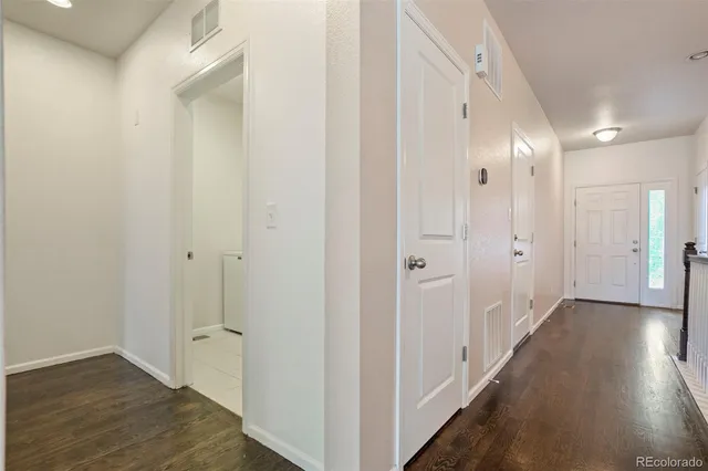 a view of a hallway with wooden floor