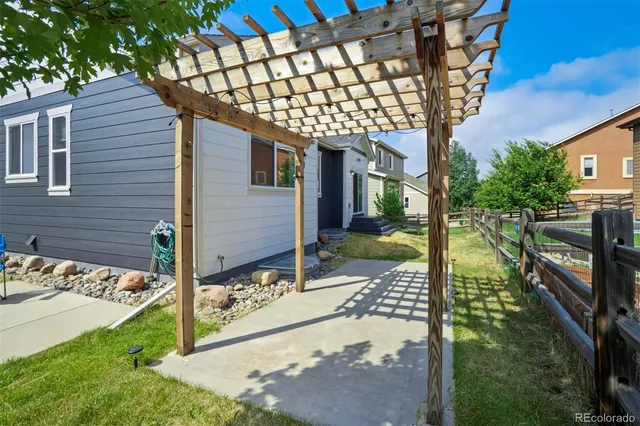 a patio with table and chairs and potted plants