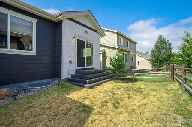 a view of a house with backyard and sitting area