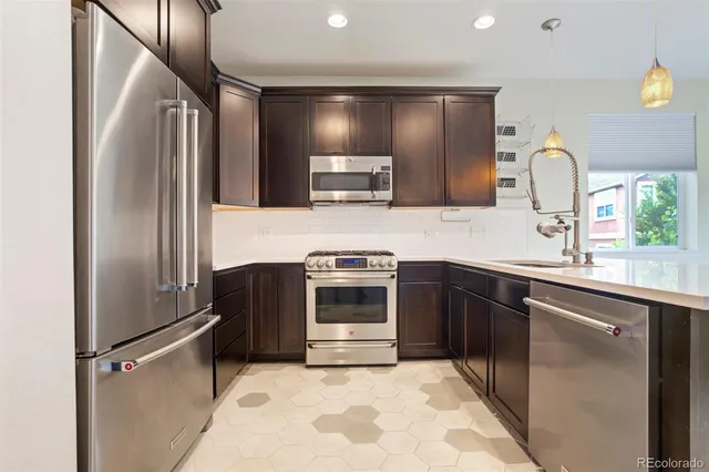 a kitchen with granite countertop a refrigerator and a sink