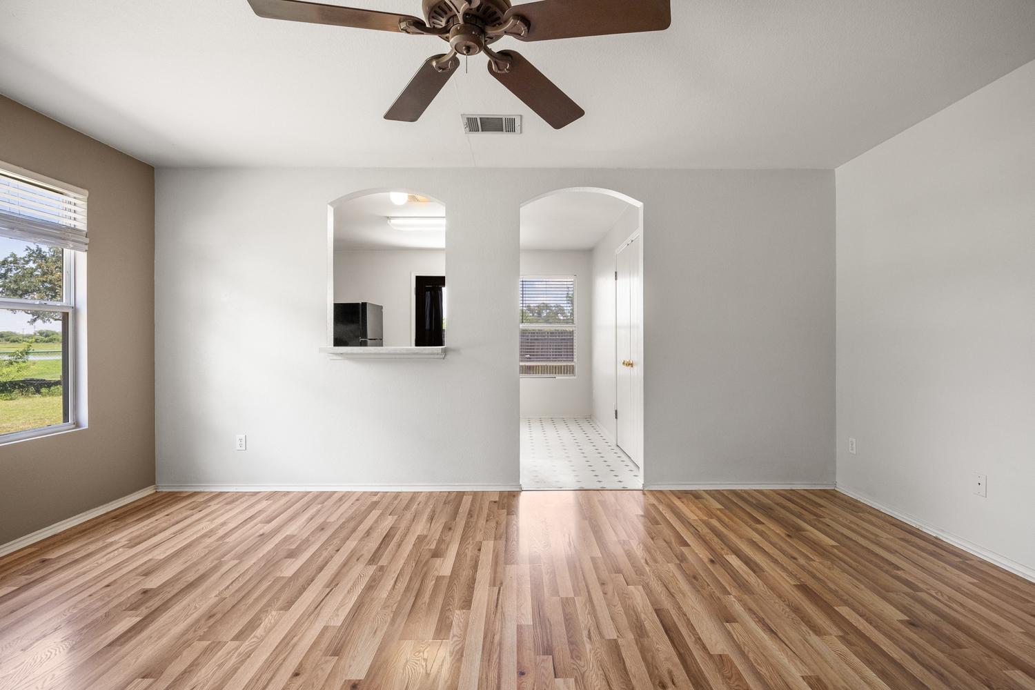 359 Spring Branch Loop Kyle, TX 78640 - Photo 6 of 17 a view of empty room with wooden floor and fan