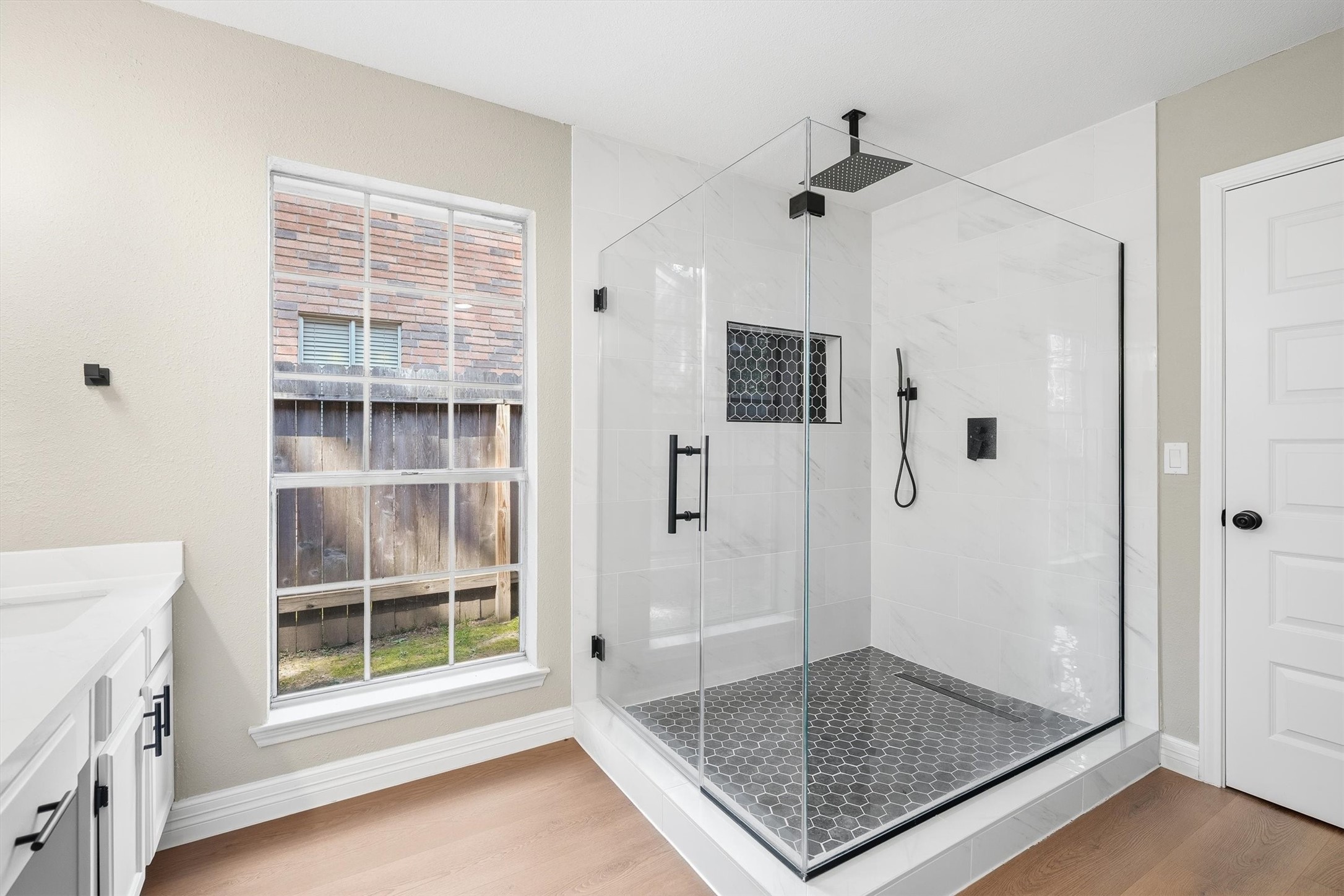 3 Still Corner Place Spring, TX 77381 - Photo 18 of 34 The oversized shower is a real showstopper here, finished with a rainfall showerhead, marble-look tile, and a hexagon tile floor and shower niche, for a spa-like feel.