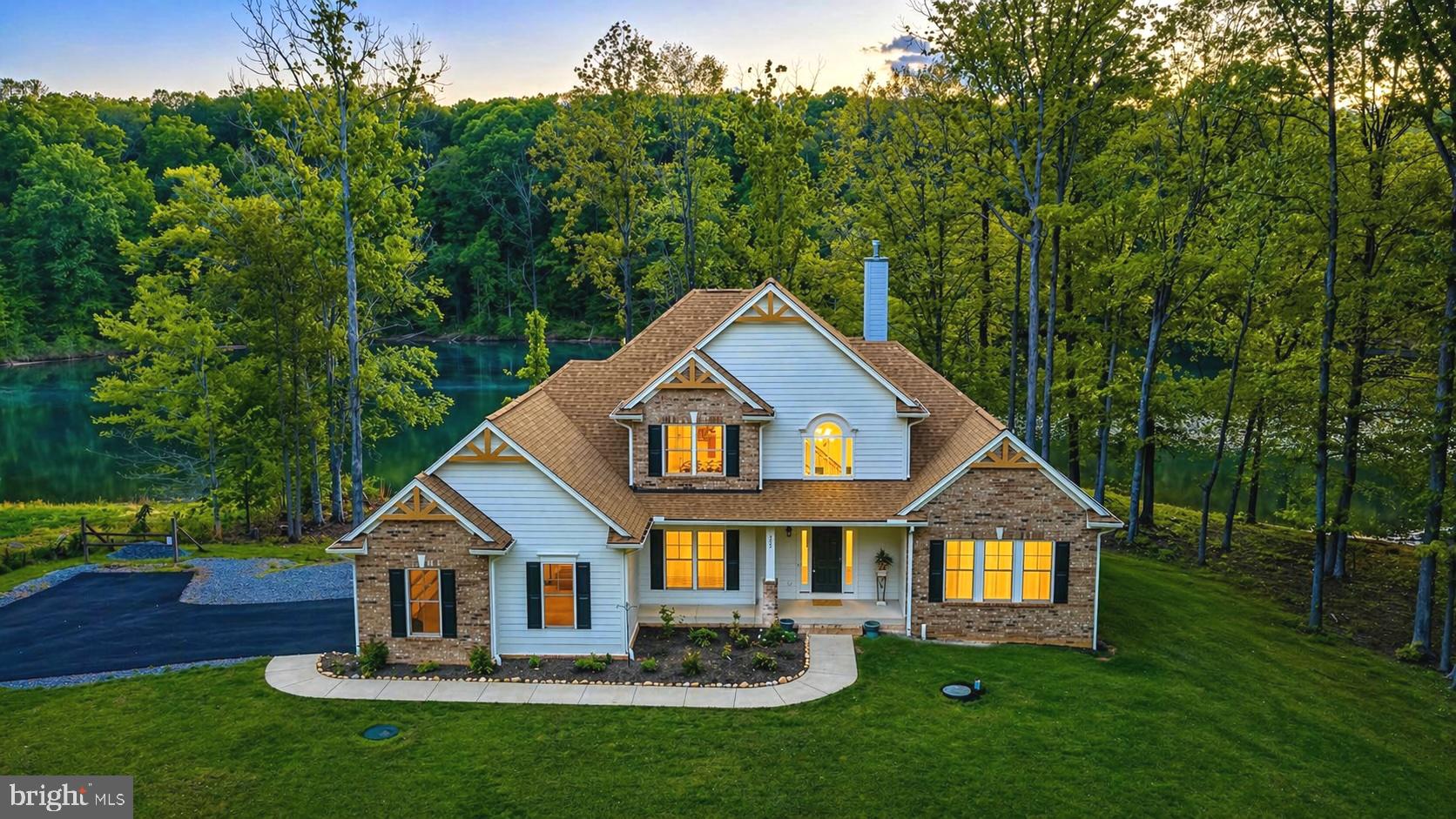 a front view of a house with a yard and green space