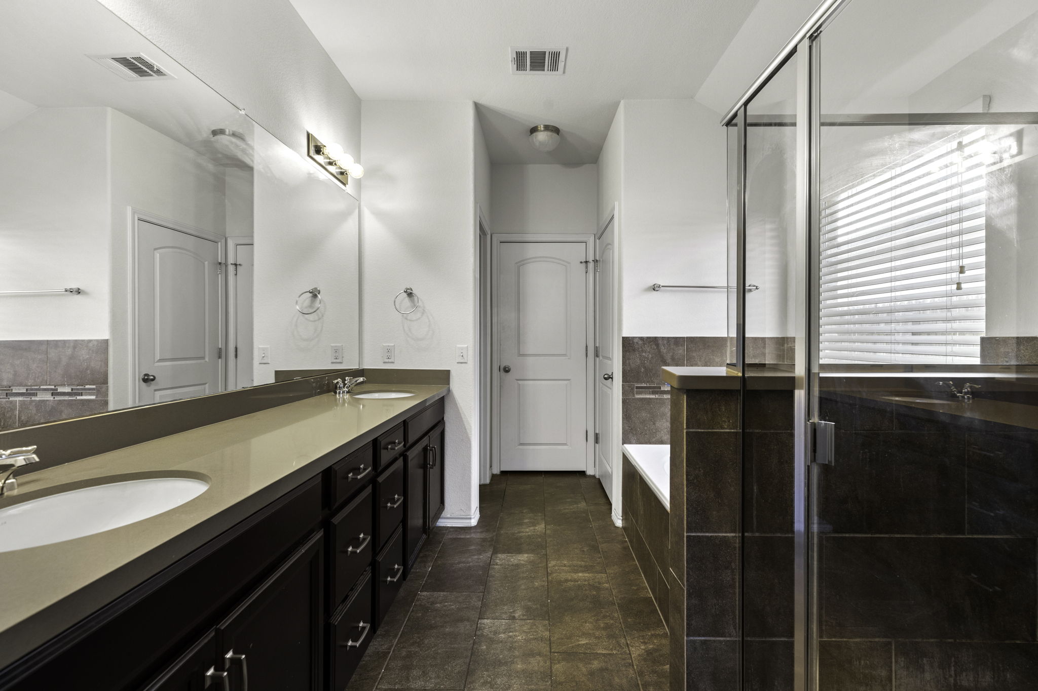 3116 Bragg Place Pflugerville, TX 78660 - Photo 16 of 29 a spacious bathroom with a granite countertop sink a mirror and a shower