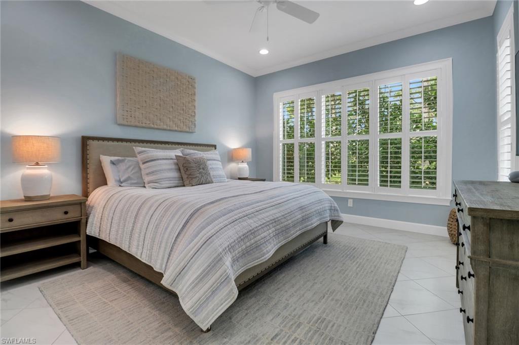 6509 Dominica Drive, Unit 101 Naples, FL 34113 - Photo 5 of 33 a spacious bedroom with a bed and a large window