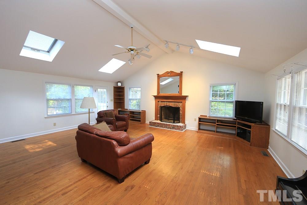 409 Vernon Terrace Raleigh, NC 27609 - Photo 6 of 23 An Addition to the Home...the Den/Great Room Complete with Wood Burning Fireplace and Exterior Ash Clean Out. Soaring Cathedral Ceilings and Skylights for Natural Light with Hardwood Floors.