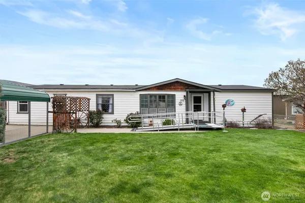 a view of a house with a yard and sitting area