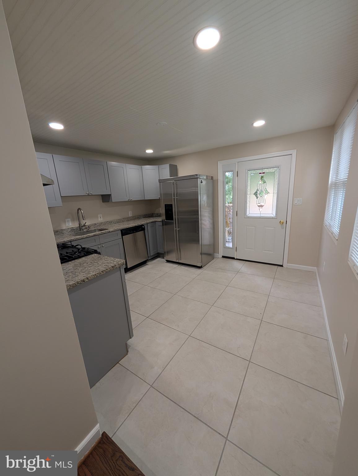 11926 Bluhill Road Silver Spring, MD 20902 - Photo 4 of 27 a kitchen with stainless steel appliances granite countertop a refrigerator and a stove top oven