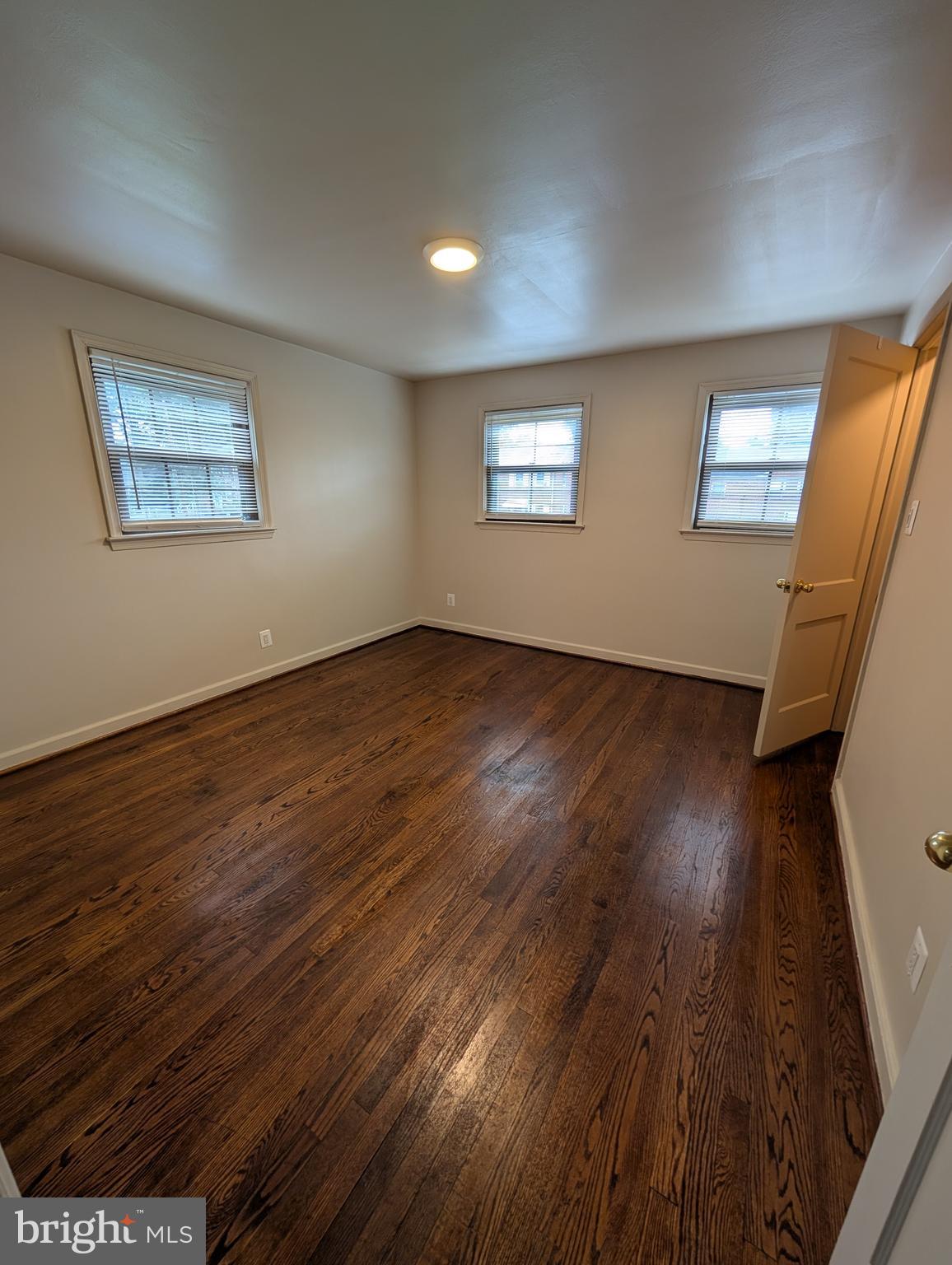 11926 Bluhill Road Silver Spring, MD 20902 - Photo 10 of 27 a view of an empty room with wooden floor and a window