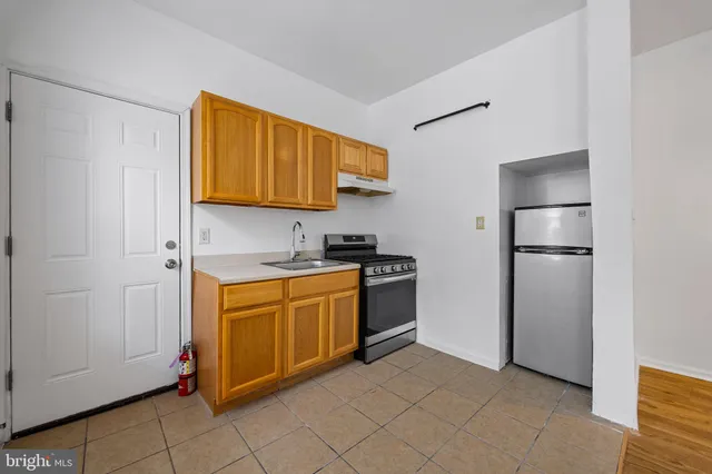a kitchen with stainless steel appliances granite countertop a refrigerator and a stove