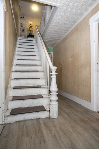 a view of a hallway with wooden floor and stairs