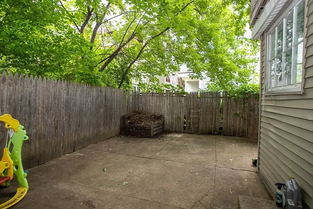 a view of a backyard with a chair and potted plants