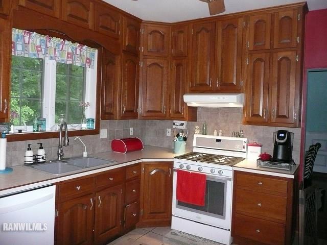 6570 West Cook Road Lena, IL 61048 - Photo 11 of 58 a kitchen with stainless steel appliances wooden cabinets and a stove top oven