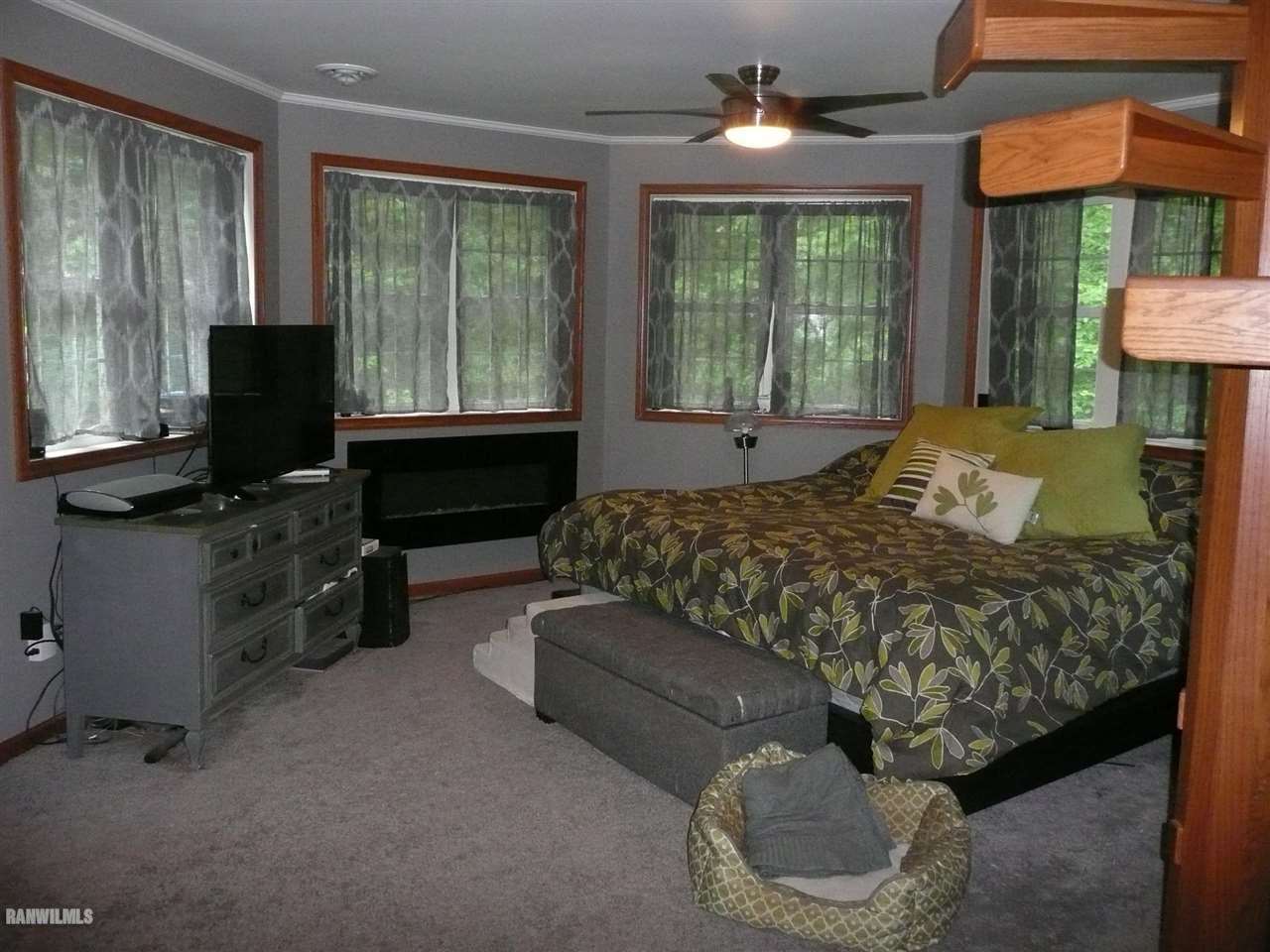 6570 West Cook Road Lena, IL 61048 - Photo 24 of 58 a bedroom with a bed and a chandelier